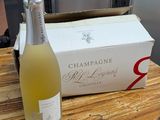 une bouteille de champagne posée sur une table à côté d'un carton de vin