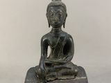 statue représentant une personne assise en position du lotus sur un bloc de bois