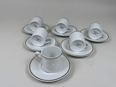 six tasses et soucoupes posées sur une table blanche