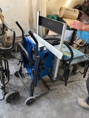 un homme debout à côté d'un chariot sur lequel se trouve une machine