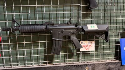 une arme exposée dans une vitrine grillagée