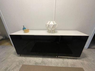 une armoire noire et blanche sur laquelle est posé un vase