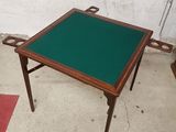une petite table au plateau vert posée sur un sol en béton
