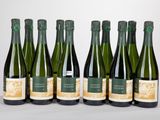 six bouteilles de vin sont alignées sur une table