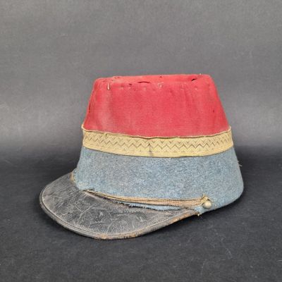 un vieux chapeau orné d'une bande rouge, bleue et jaune