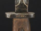 a close up of a sword with a wooden handle on a black background