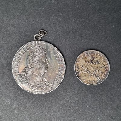 une vieille pièce d'argent et une pièce d'argent posée sur une surface noire