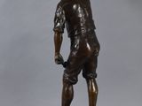 bronze statue of a boy with a basket on his head