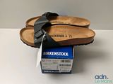 pair of birkenstock sandals on top of a box on a table