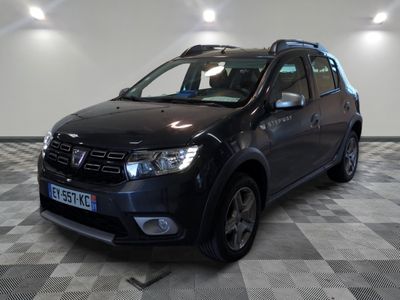une photo d'une dacia noire garée sur un sol en damier