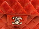 a red chanel bag that is on a stand