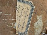 un morceau de papier sur lequel il y a quelque chose d'écrit, posé sur un morceau de bois