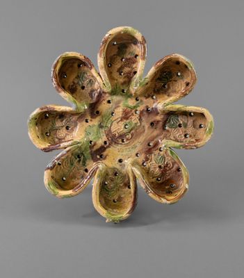 a close up of a flower shaped object on a gray surface