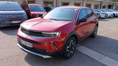 un SUV rouge garé sur un parking à côté d'autres voitures