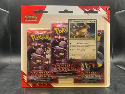 Deux cartes Pokémon se trouvent dans un emballage en plastique posé sur une table