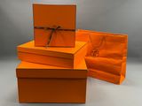 Trois boîtes orange sont empilées les unes sur les autres sur une table
