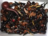 une boîte blanche remplie d'une grande variété de pipes à fumer