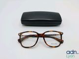 les lunettes se trouvent à côté d'un étui noir, posées sur une surface blanche