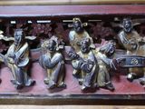 une sculpture en bois représentant un groupe de personnes, posée sur une table