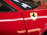 ferrari badge on the side of a red sports car