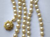 gros plan d'un collier de perles sur une surface blanche