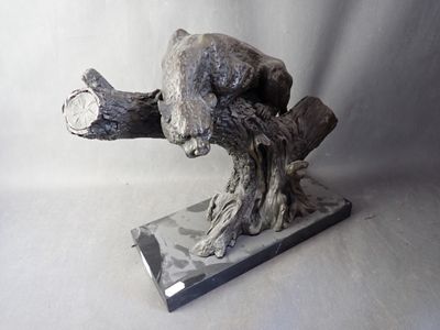 a sculpture of a bear that is sitting on a branch
