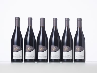 six bouteilles de vin sont alignées sur une table