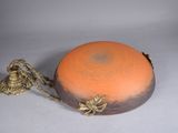 un bol orange et noir entouré d'une corde