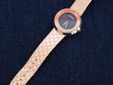a close up of a watch on a blue surface with a black background