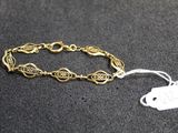 a close up of a gold bracelet with a tag on it