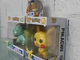 two pikachu and pikachu pop vinyl figures on a glass table