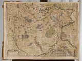 une vieille carte posée sur un chevalet en bois, avec un rideau en arrière-plan