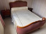 a bed with a quilt on top of it in a room