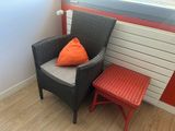 a chair and a table with a pillow on it in front of a radiator