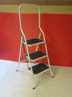 an image of a three step ladder against a red wall