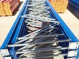 a man standing in front of a large pile of steel beams