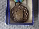 a medal in a box with a ribbon around it