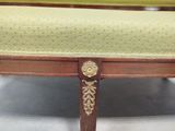 a wooden bench with a green upholstered seat
