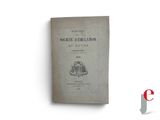 an old book sitting on top of a white table next to a red and white logo