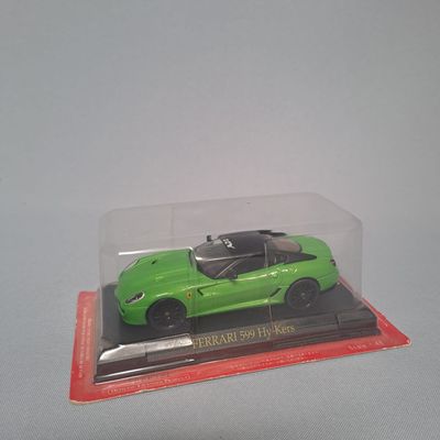 a green toy car in a clear box on a table