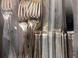 a lot of silverware on a table with a knife and fork
