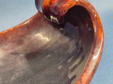a brown and black bowl sitting on a blue surface