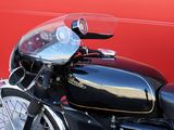 a close up of a motorcycle parked in front of a red wall