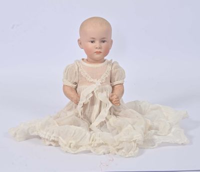a baby doll sitting on a white surface with a white background