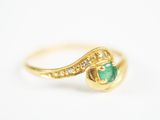gros plan d'une bague en or avec une pierre verte