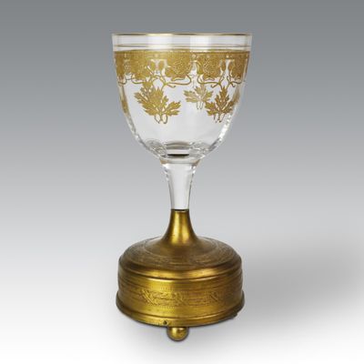 an antique glass goblet with a gold leaf design on it