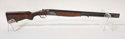 Le fusil est exposé sur un socle en acrylique transparent.