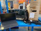 two laptops sitting on a blue table in a warehouse