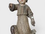figurine représentant un enfant tenant un morceau de bois dans une main et un autre morceau de bois dans l'autre