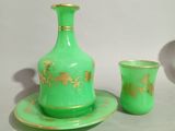 two green vases and a cup on a table
